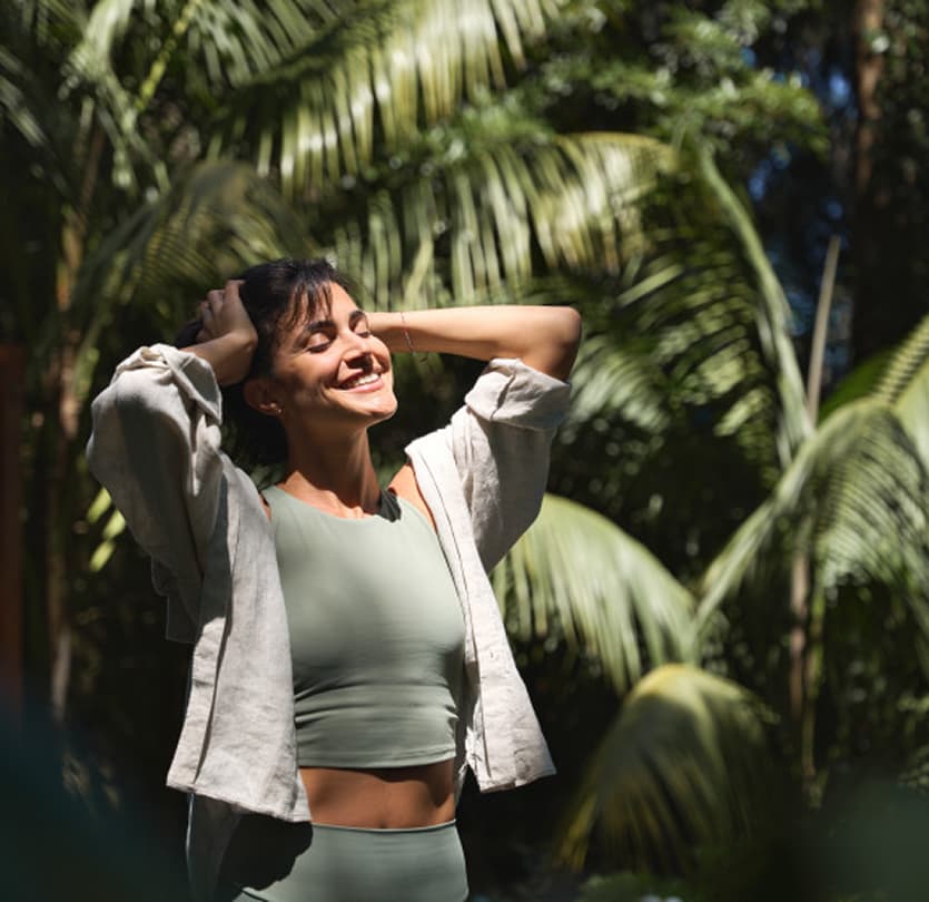 Woman smiling among tropical palms