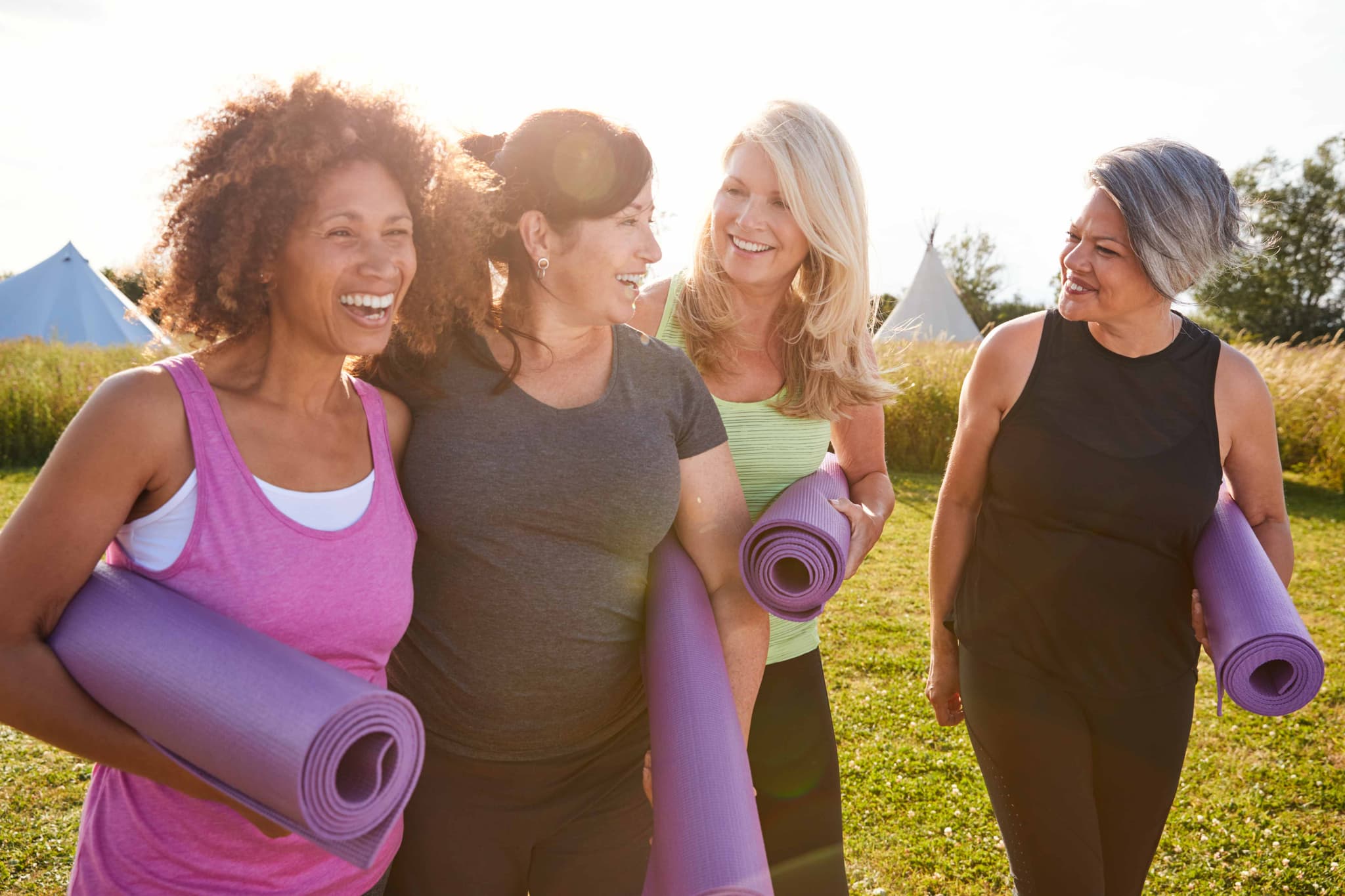 Women with yoga mats outdoors